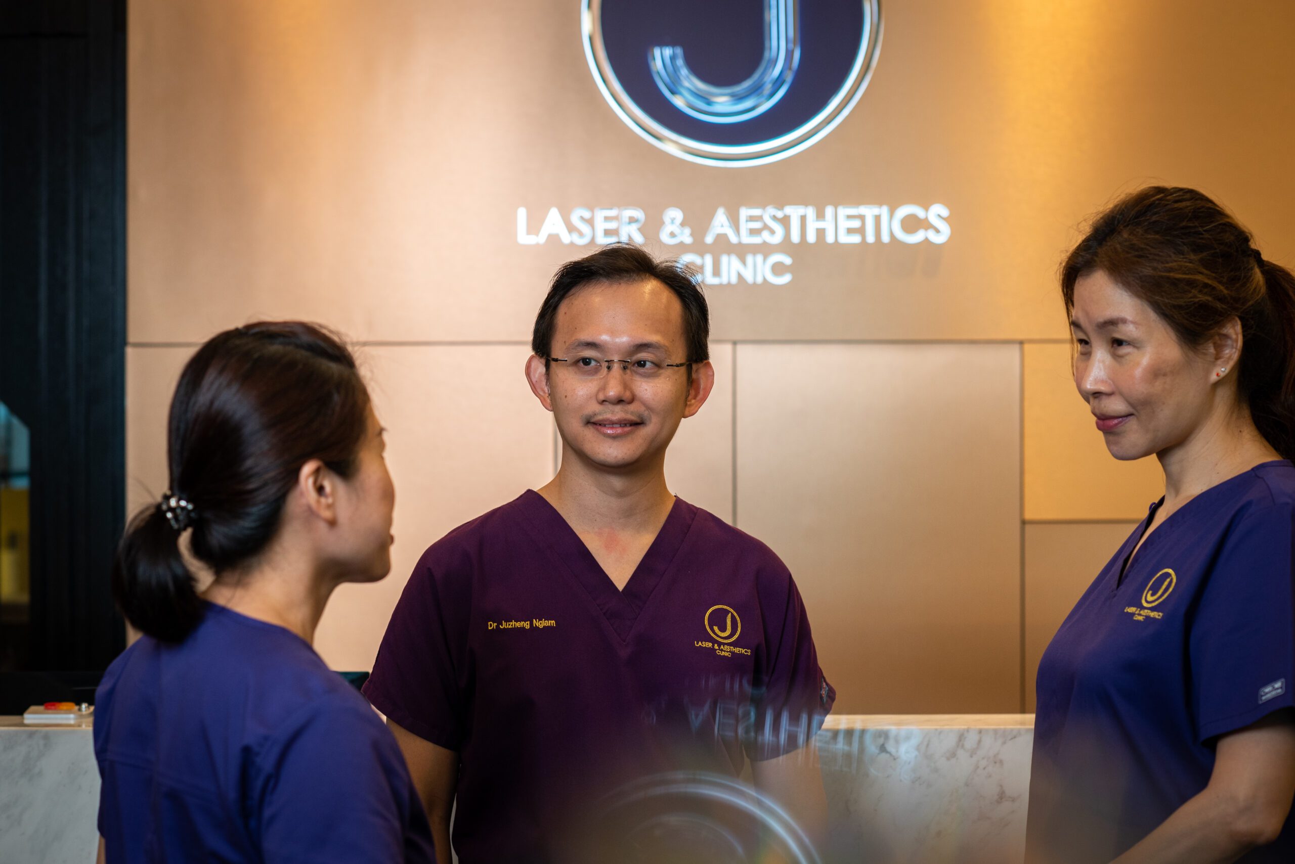aesthetic doctor ngiam juzheng with 2 team members in clinic uniforms
