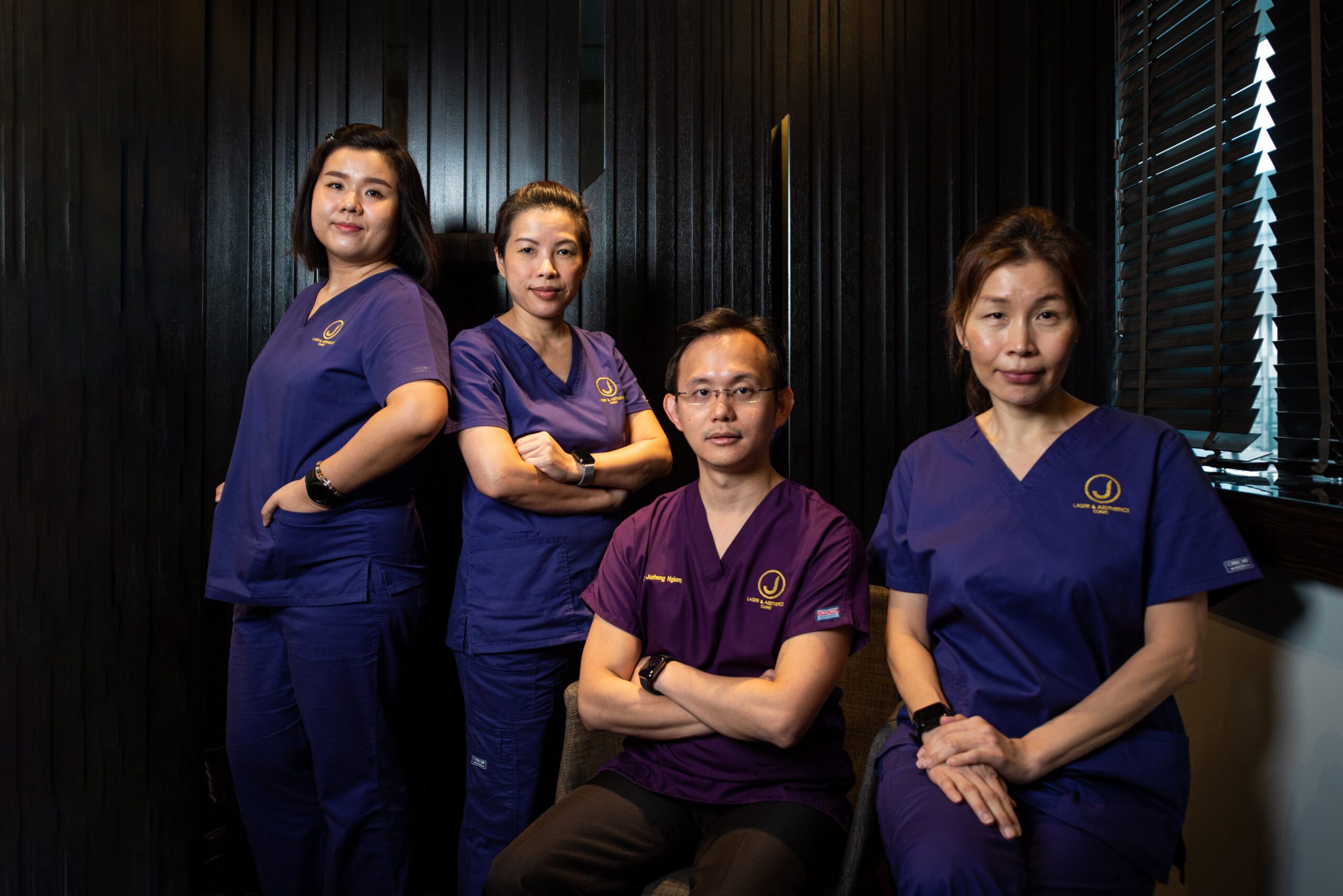 aesthetic doctor ngiam juzheng and team by the window dressed in clinic uniforms